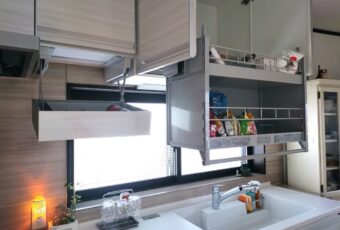 キッチンを一番使われる奥様のご希望で、吊戸棚にはシステム昇降ラック「アイラック」を設置させていただきました。<br>ハンドルを引っ張るだけでラックが降りてくるので、使いやすさが格段にアップします。